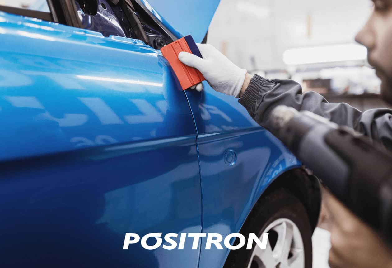 Homem instalando adesivo azul no carro