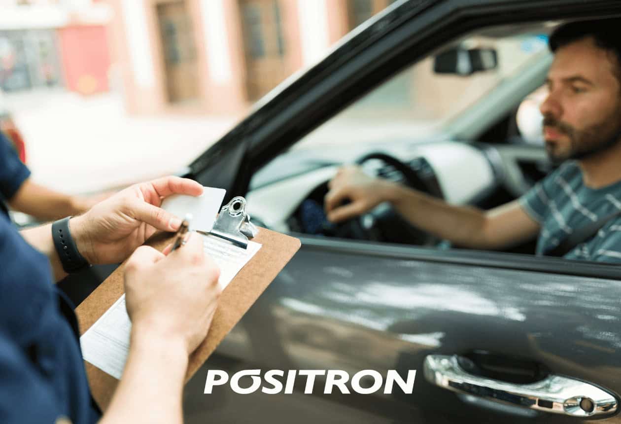 guarda preenchendo multas de trânsito e condutor dentro do carro