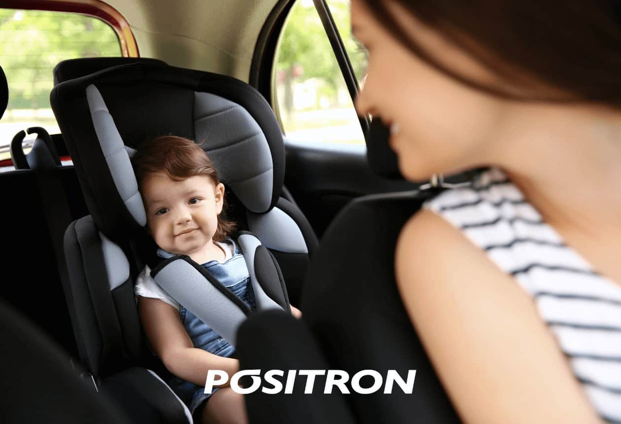 mãe olhando o filho na cadeirinha dentro do carro